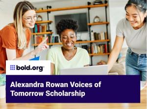 A group of three, diverse college-aged women grouped around a desk and looking at a laptop screen