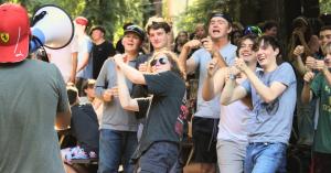 Campers cheer and clap outdoors as a staff member speaks through a megaphone at Mt. Gilead Bible Camp and Conference Center in Sebastopol, California.