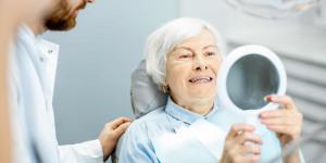 An elderly lady smiling happily with her newly placed dental implants at Aspley Elite Dental Care