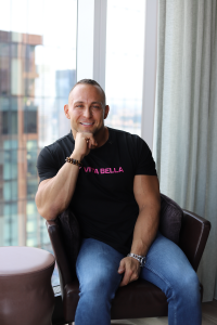 Phil Vella, Founder of Vita Bella, seated and posed for a professional portrait promoting the Bringing Alphas Back men’s health podcast.