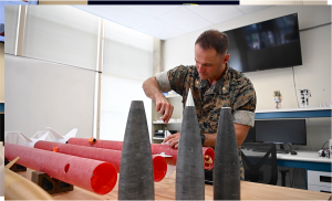 U.S. Marine Corps Maj. Dillon Pierce, a master’s and doctoral graduate of NPS, prepares experimental rockets for test flight while completing his doctorate in space systems engineering in June 2025.