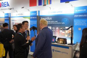 A visitor listening to representatives from Korea Lighthing