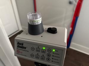 An image of an air allergen sampling capture capsule and machine inside a home to collect possible allergens in the air. Test run by EnviroPro 360.