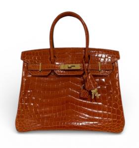 A picture of the Hermès Birkin 30 in Orange Shiny Porosus Crocodile that Lena of Goldpawnership sold for $28,999 in 2024. Louis Vuitton, Chanel, Hermès, Prada, Gucci, Saint Laurent, Goyard, Tiffany & Co., Tom Ford and Celine. Luxury gold jewelry and watches, too.