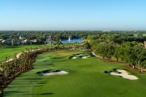 Aerial view of Vineyards Country Club’s renovated North Course in Naples, Florida, featuring sweeping fairways, sculpted white-sand bunkers, native palms and oak trees, and lakes with fountain features surrounded by residences.