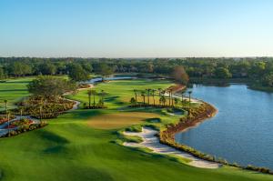 Aerial view of Vineyards Country Club’s renovated North Course in Naples, Florida, showcasing a lakeside green with sculpted white-sand bunkers, winding cart paths, native palms and lush fairways framed by water and natural landscaping.