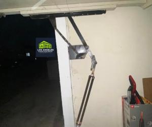 Professional technician performing a garage door spring repair in a Los Angeles residential garage.