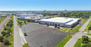 Aerial view of the Lithium Battery Company headquarters and manufacturing facility in South Tampa, Florida, showing the full 84,000 sq. ft. building and surrounding area near MacDill Air Force Base.