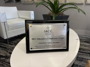 The IACC Certification plaque sits on a table, on display in the lobby of the OLC.