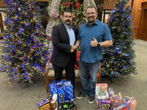 Sunny Glen Interim CEO Wayne Lowry receives toy donations from the Greater McAllen Association of Realtors, whose generosity helped bring comfort and joy to children during the Christmas season.