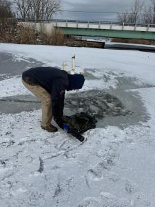 Man Installing EM-2Q system into icy body of water