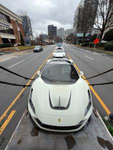 Ferrari, Lamborghini, and Mercedes G-Class SUV being loaded for enclosed transport.