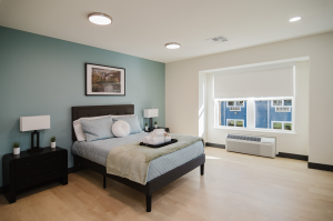 shot of a bedroom with a bed and a wide window