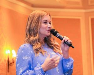 Lise Reitsma presenting on stage at a business event.