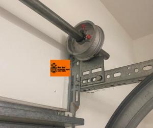 Next Hour Garage Door Repair technician fixing a broken torsion spring on a residential garage door in Santa Clarita, CA.