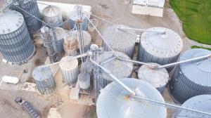 Drone shot of biofuel facility featuring metal silos and farm fields surrounding