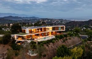 Pool deck view of the 2423 Briarcrest Residence, perched on a hillside and opening to panoramic views, with three levels expressed through distinct architectural treatments.