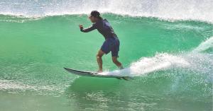 Surfer riding the waves as part of surf therapy program at South Shores Recovery