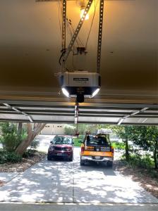Professional technician from Easy Garage Door Repair fixing a broken garage door spring and adjusting tracks at a residential home in Houston, Texas.