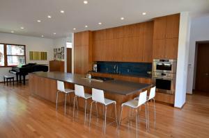 Modern Denver kitchen featuring a large functional island with seating and floor-to-ceiling warm wood cabinetry, illustrating high-ROI renovation upgrades.