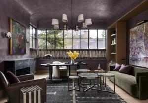 Study by Benjamin Johnston Design with aubergine plaster walls, black marble fireplace, olive green sofa, and steel-framed windows. Featured by Architectural Digest.