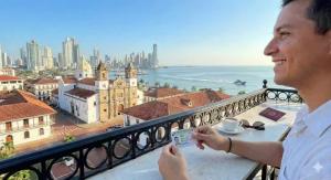 a man with Panama Residency looking to the city from Panama apartment balcony