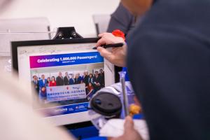 A China Airlines representative signs a commemorative display reading “Celebrating 1,000,000 Passengers” during a ceremony at Ontario International Airport, marking the airline’s 1 millionth passenger milestone on the Ontario–Taipei route.