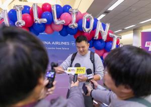 Mr. Cheng, the 1 millionth passenger on China Airlines’ Ontario–Taipei route, smiles while speaking with media beneath a balloon arch during a celebration at Ontario International Airport.