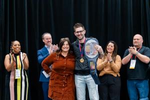 Kirk Teachout on stage with Dr. Devinn Geeson at Yankee Dental Congress 2026 after winning the Dentistry’s Got Talent Marketing Showdown.