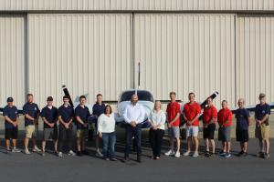 M2A's Staff posing in front of Hangar and Piper Seneca II aircraft