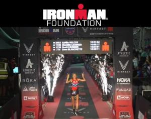 woman crossing finish line at ironman