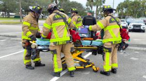 First responders providing emergency care during a controlled teen driving safety reenactment focused on education and prevention.