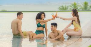 Group of friends enjoying the outdoor pool at Discovery Samal, surrounded by tropical greenery and overlooking the Davao Gulf.