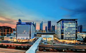 Dubai World Trade Centre convention district exterior at dusk with exhibition buildings and business skyline.