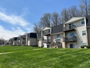 Exterior view of Pine Bridge Apartments in Mansfield Ohio, showing two-story brick apartment buildings with balconies and large green lawns.