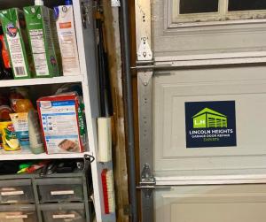 Interior view of a garage door panel showing the metal hinges, vertical track, and hardware components serviced by Lincoln Heights Garage Door Repair Experts.