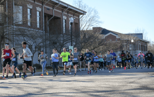 Runners of various ages participate in a community 5K race near brick academic buildings on the GSSM campus in Hartsville, South Carolina.
