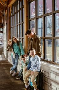 family standing with luggage in hotel connector atrium at Fair Oaks Farms