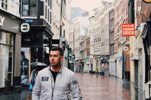 Yanik Guillemette, Montreal-based entrepreneur and investment strategist, standing on a bridge overlooking an Amsterdam canal with traditional Dutch architecture in the background.