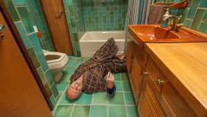 Man on bathroom floor calling for help from is senior home health care aid