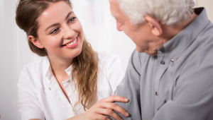 In home senior care aid with older man in wheel chair