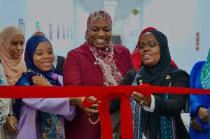 Noor Academy staff cut red ribbon at opening ceremony.