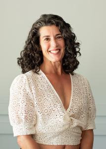 Holly Bonvissuto, Atlanta-based wellness expert and author of The Good Living Code, smiling in a cream shirt..