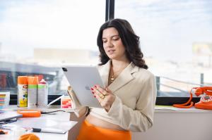 Graphic Designer, Tara Rose O’Connor, of Creative Repute, reviewing digital content on an iPad in a creative office workspace.
