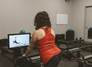 A Well Studio member using the KioskPro on-demand Pilates system by Your Reformer in Dublin, California