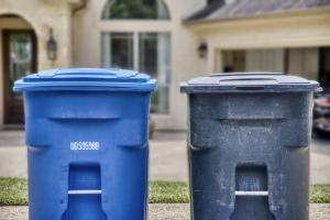 Residential waste containers placed curbside in a managed neighborhood, illustrating waste container hygiene considerations for HOAs and property managers.