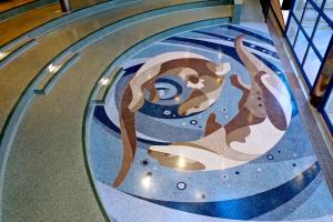 Swimming otters depicted in terrazzo in the recessed amphitheater floor at Fond du Lac College