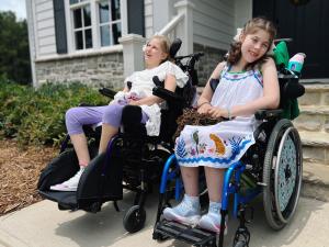 Two smiling girls in wheelchairs