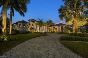 Exterior of a custom Quail West estate at dusk with golf and water views.