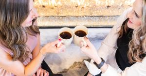 Two professionals share a coffee and conversation — a simple moment that reflects the power of authentic connection and relationship-driven communication.